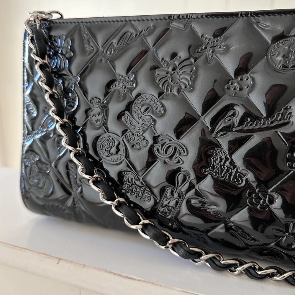 CHANEL Precious Symbols Pochette in black patent leather.